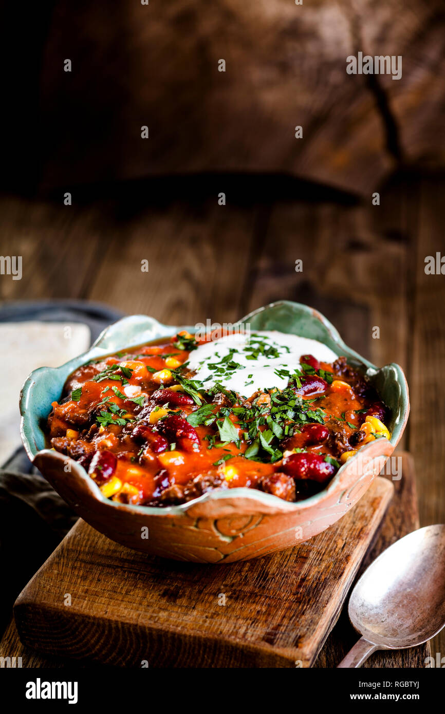 Chili con carne with kidney beans and corn, sour cream, parsley, tortilla bread Stock Photo