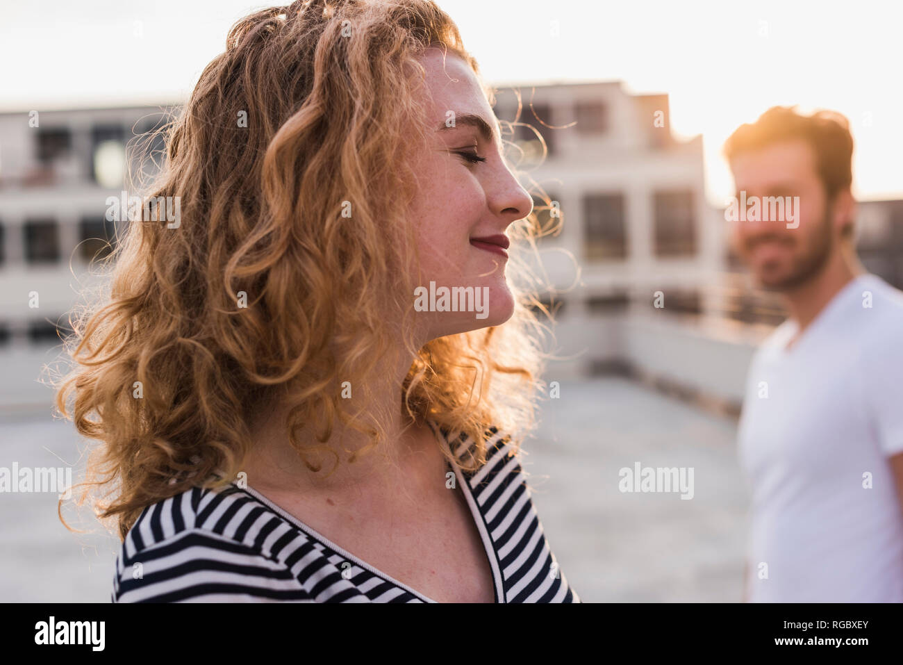 Portrait of happy young woman with eyes closed enjoying sunset Stock Photo