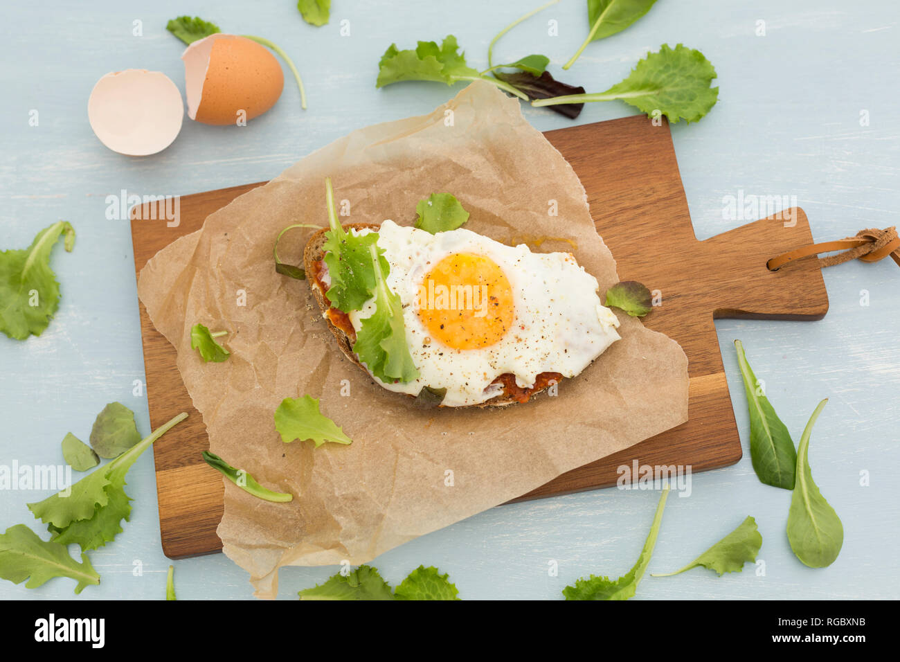 Fried egg on slice of brown bread coated with paprika cream Stock Photo