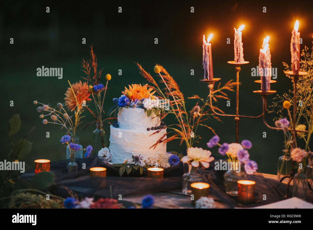 Wedding cake on table with candles outdoors Stock Photo