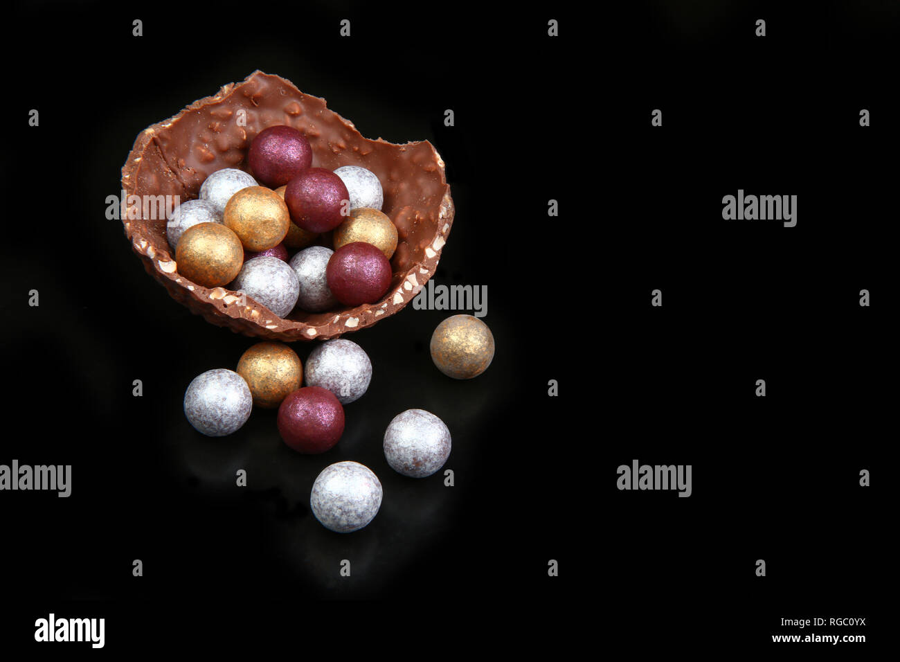 Modern sophistocated chocolate gold, silver & broze easter eggs, against a black background. Stock Photo