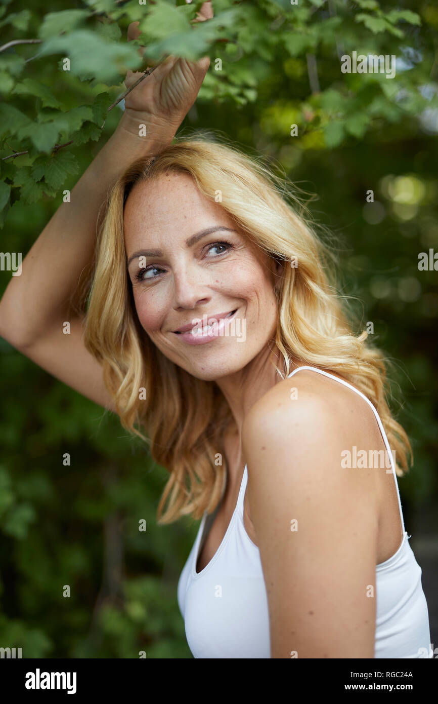 Portrait of smiling blond woman outdoors Stock Photo - Alamy