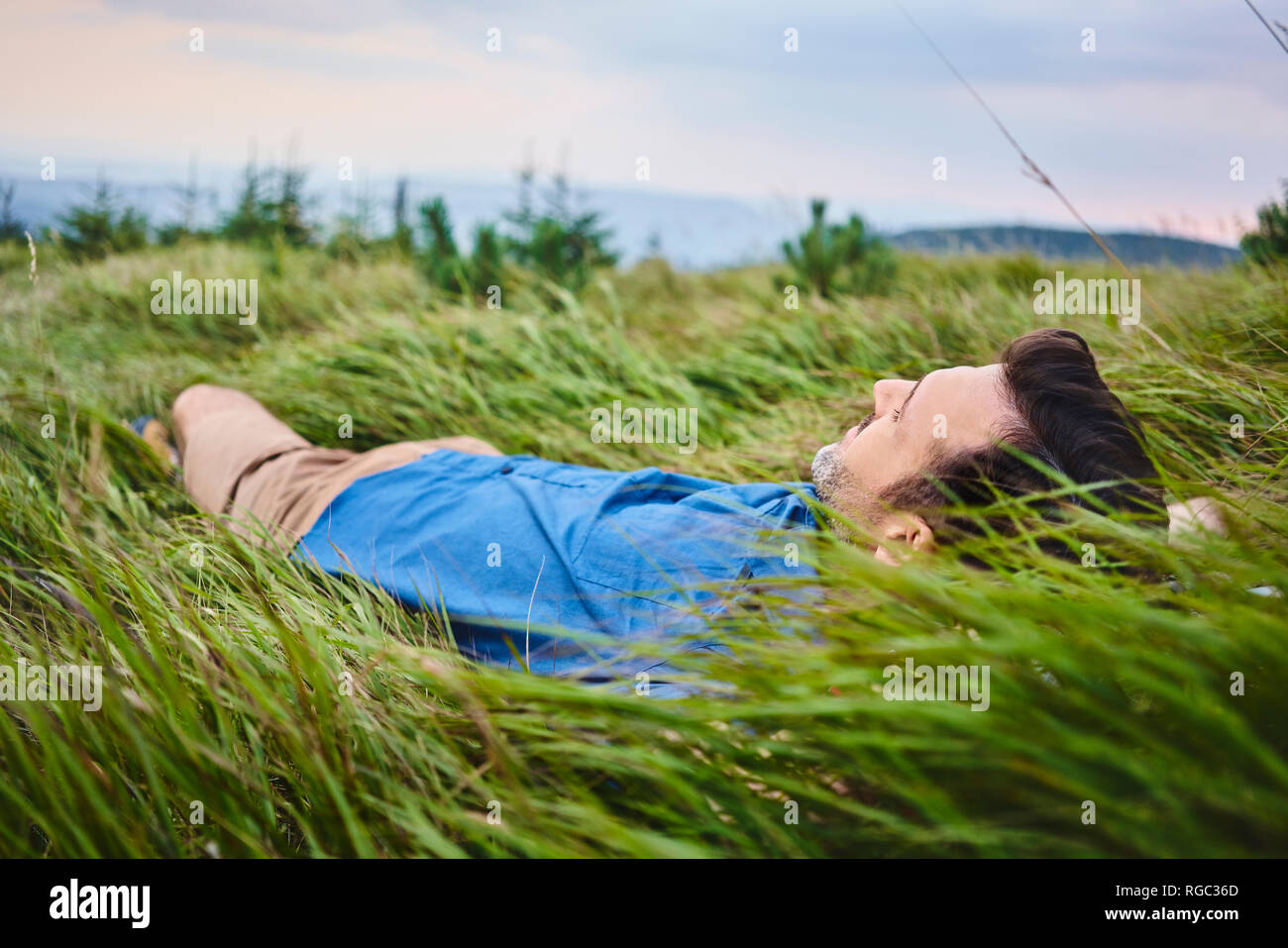 Relaxed man lying in grass Stock Photo