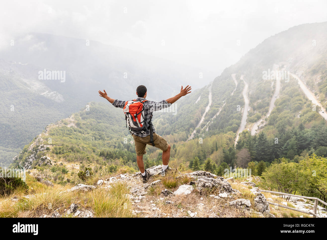 Italy, Massa, man hiking and enjoying the view in the Alpi Apuane Stock Photo
