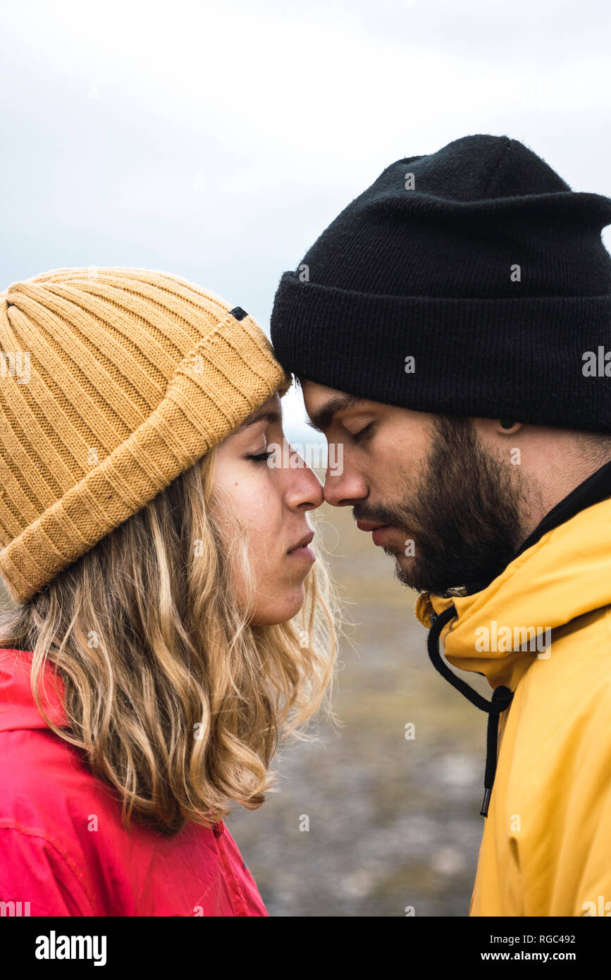 Young couple rubbing affectionately noses, Lapland, Norway Stock Photo