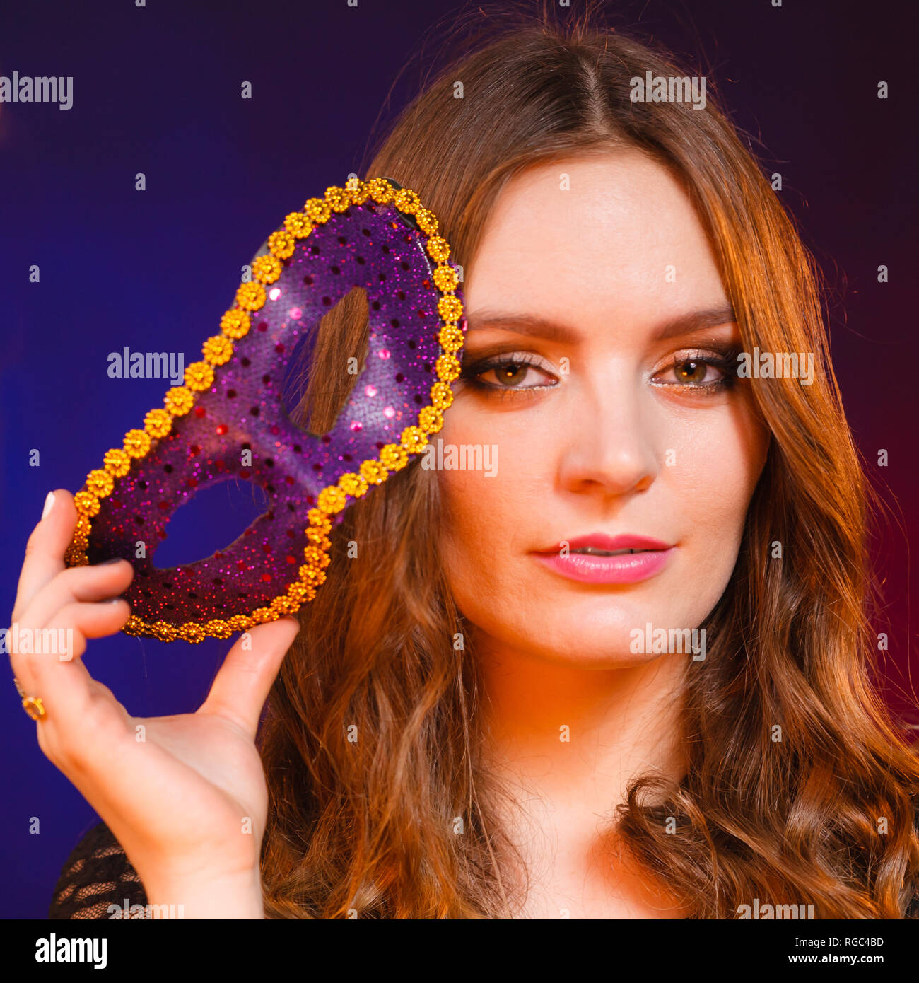 People celebration concept. Masquerade. Beautiful girl holding carnival  mysterious mask on dark Stock Photo - Alamy