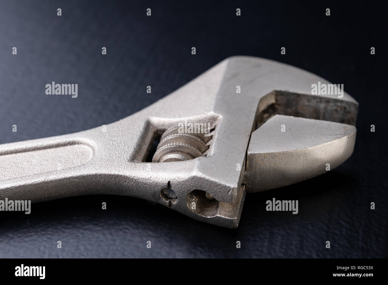 An old special wrench for a plumber. Tools for home repairs. Dark background. Stock Photo