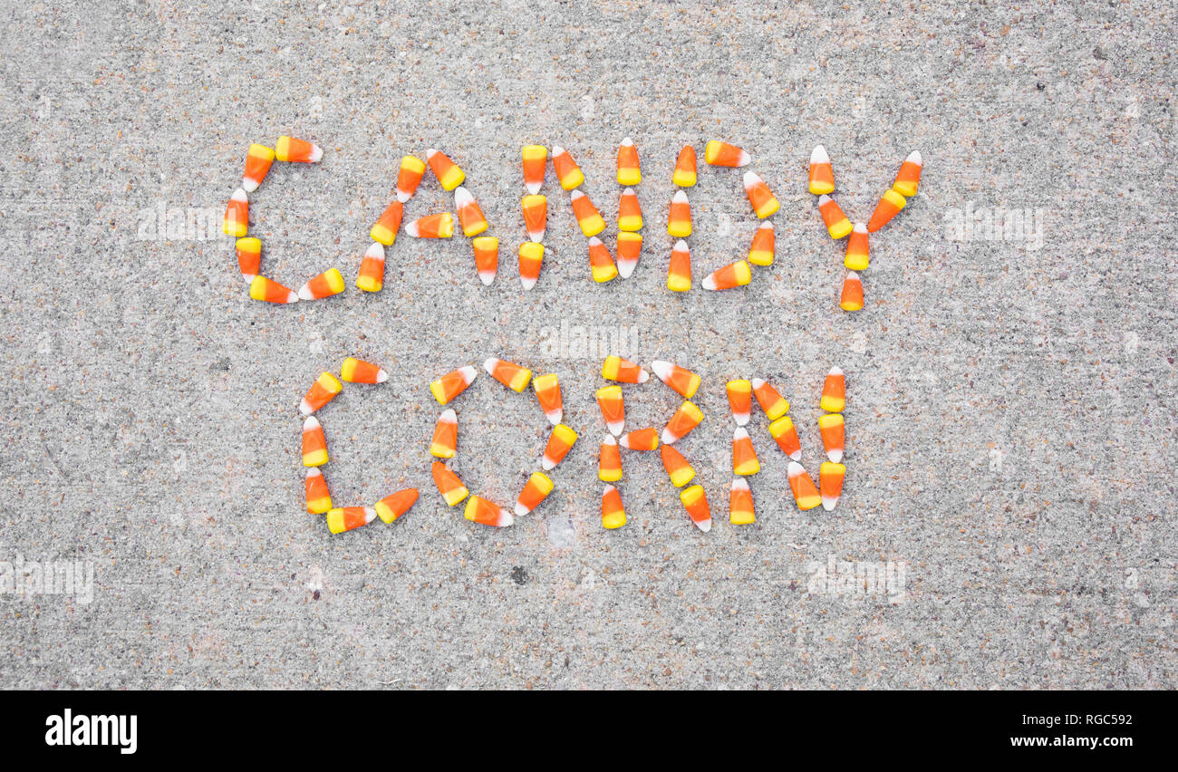 The words Candy Corn spelled out with candy corn on a sidewalk.  The words are centered in the photo. Stock Photo