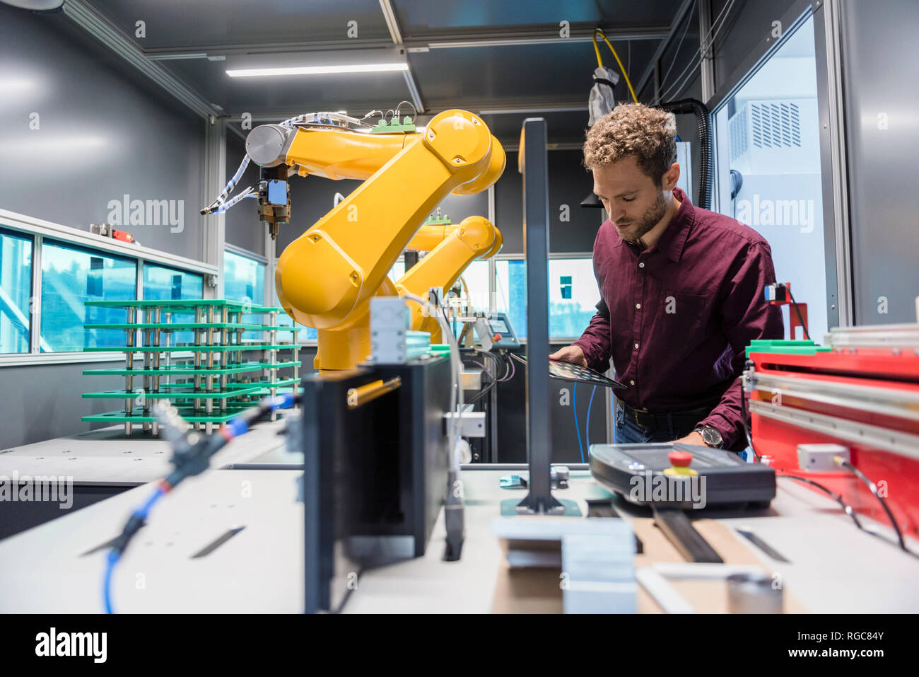 Businessman checking industrial robot in high tech company Stock Photo