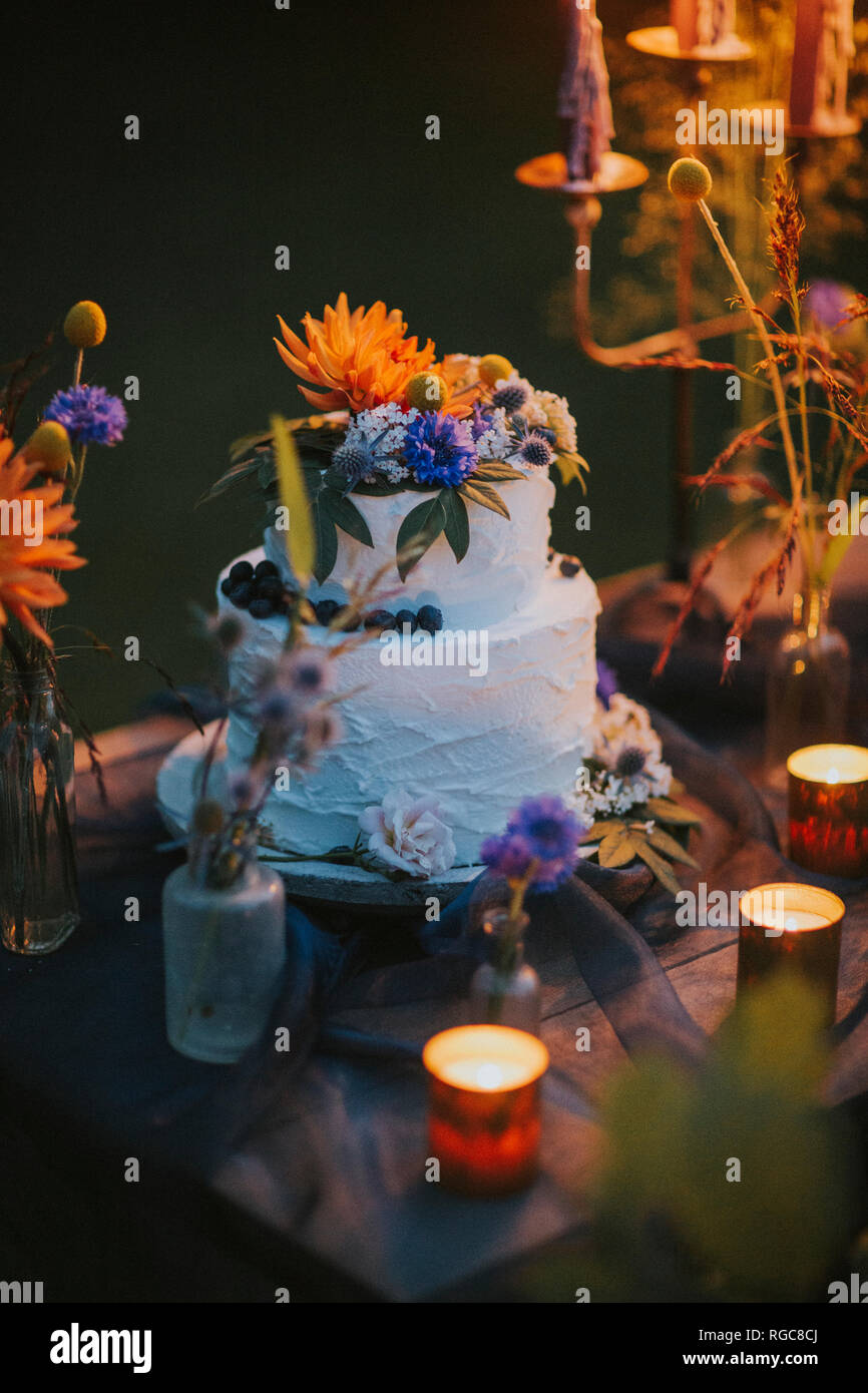 Wedding cake on table with candles outdoors Stock Photo