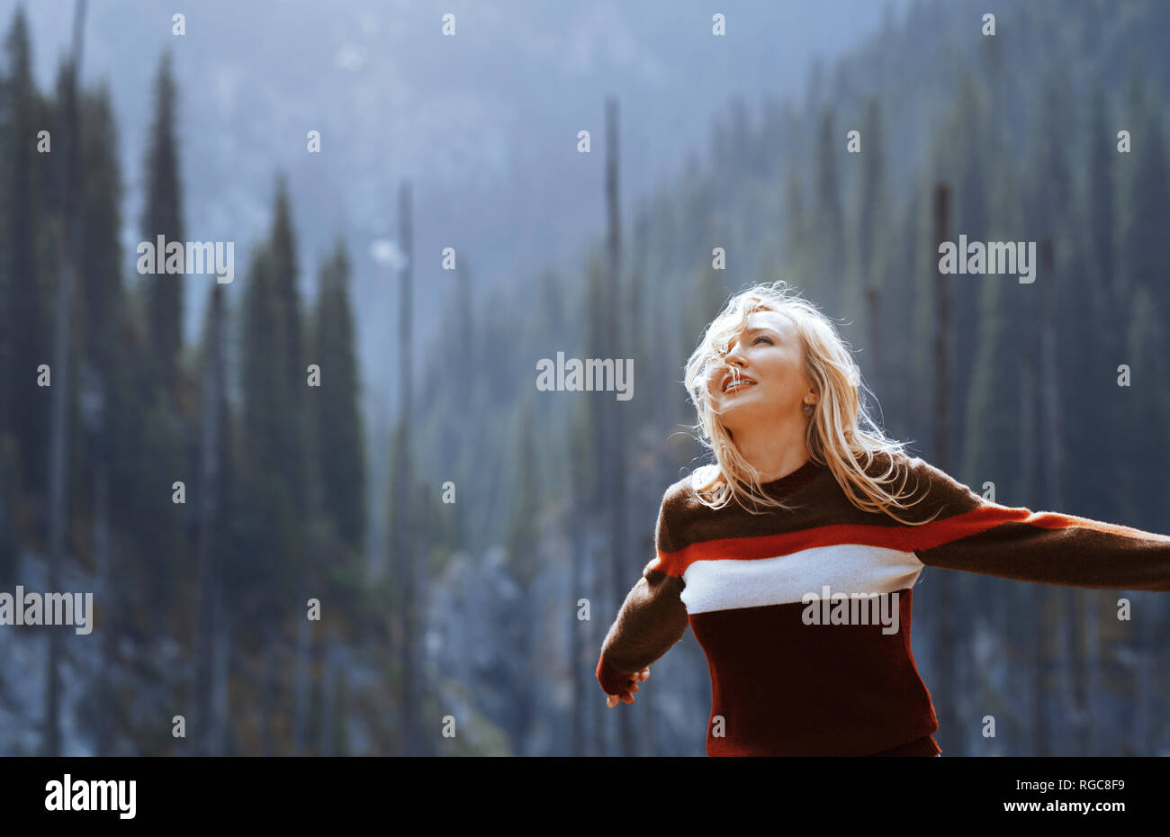 Happy blond woman, arms outstretched Stock Photo