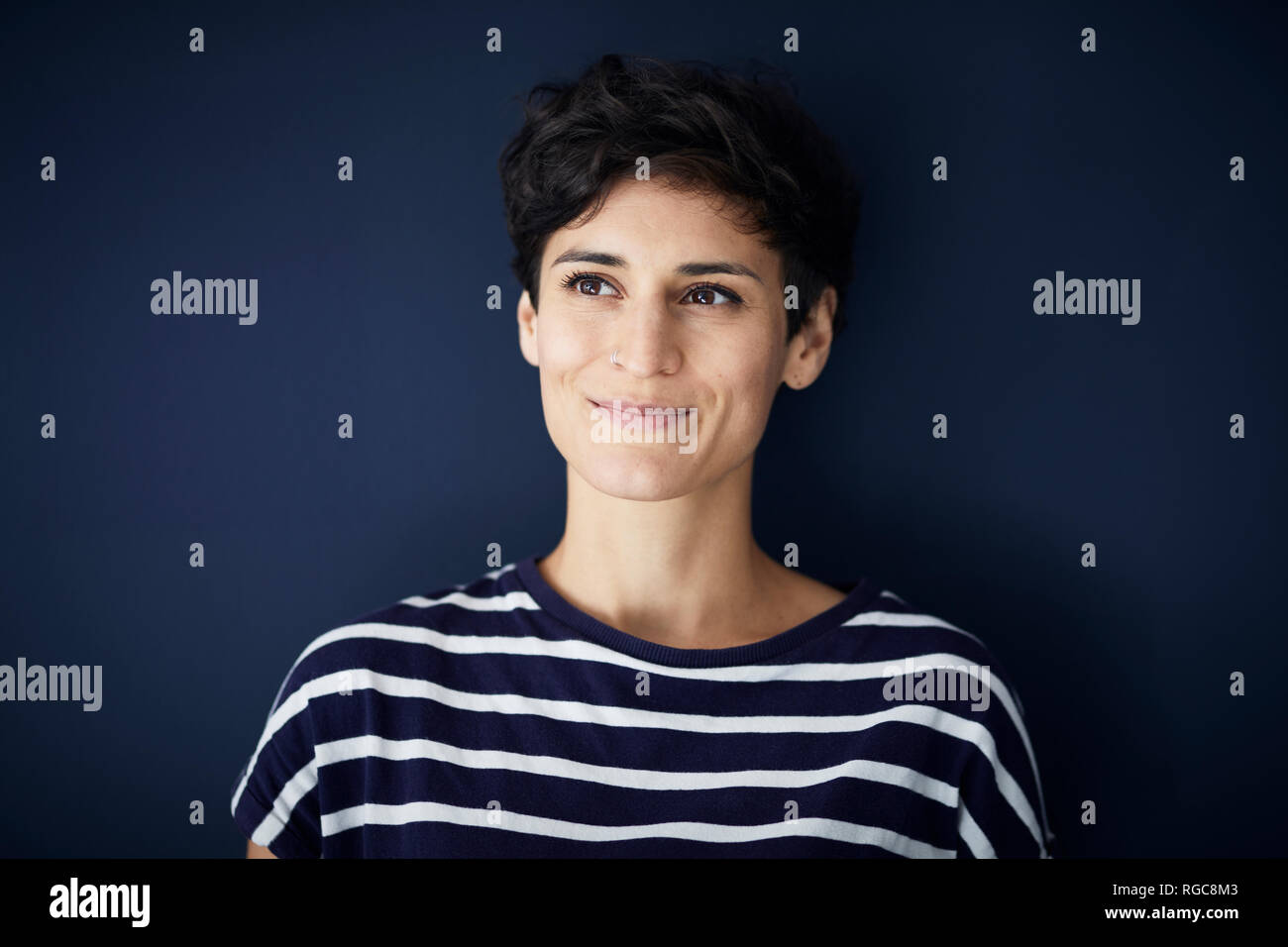 Portrait of smiling woman at blue wall Stock Photo
