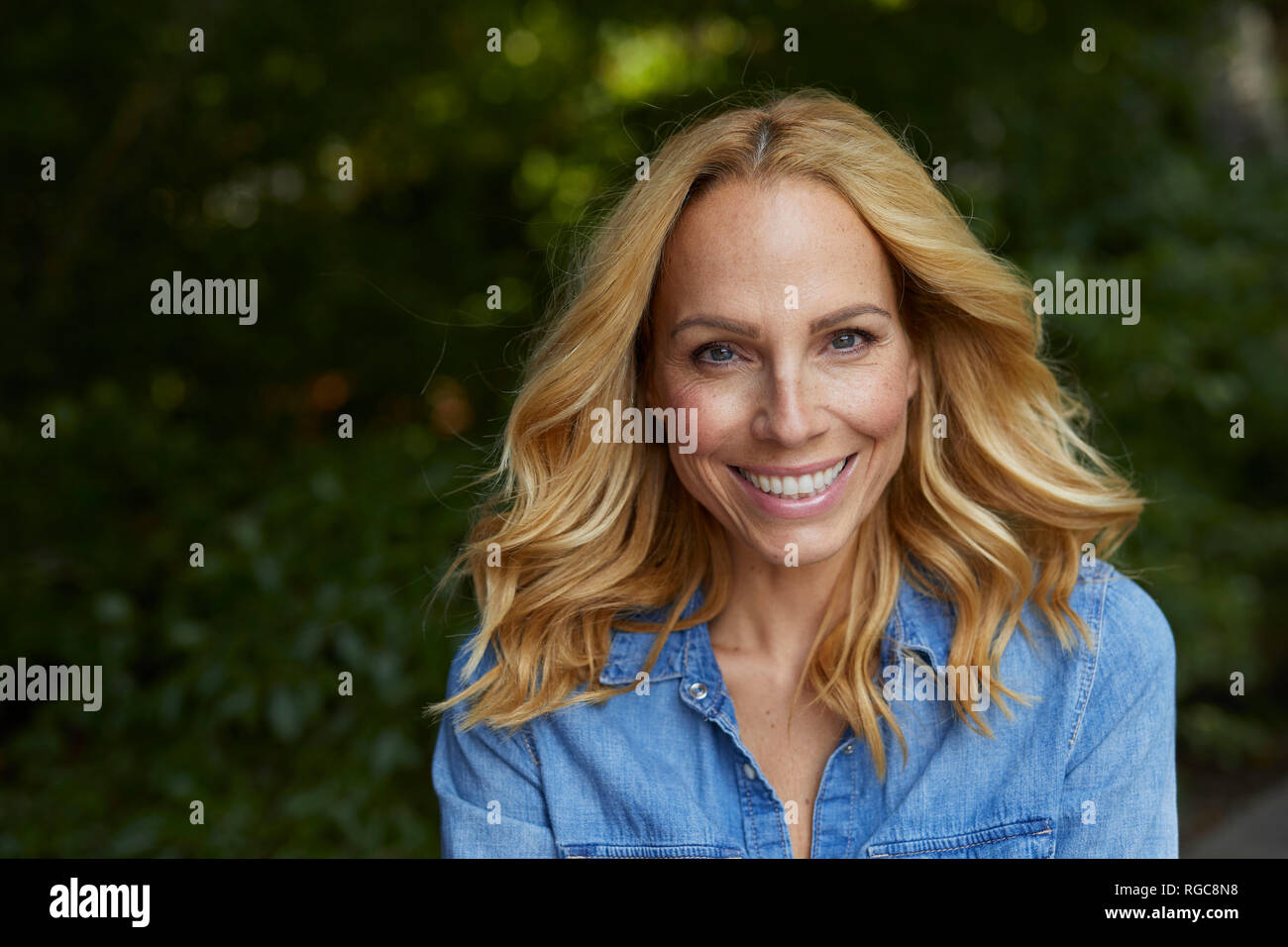 Portrait of smiling blond woman outdoors Stock Photo - Alamy