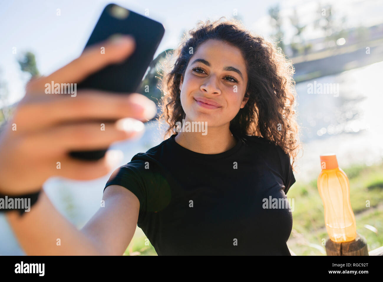 Sportive young woman taking a selfie at the riverside Stock Photo