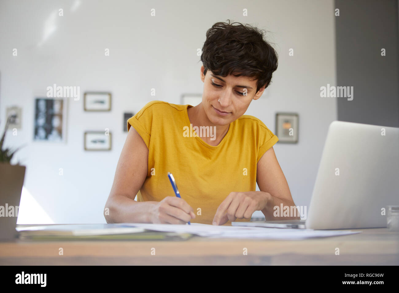 Woman working at table at home Stock Photo