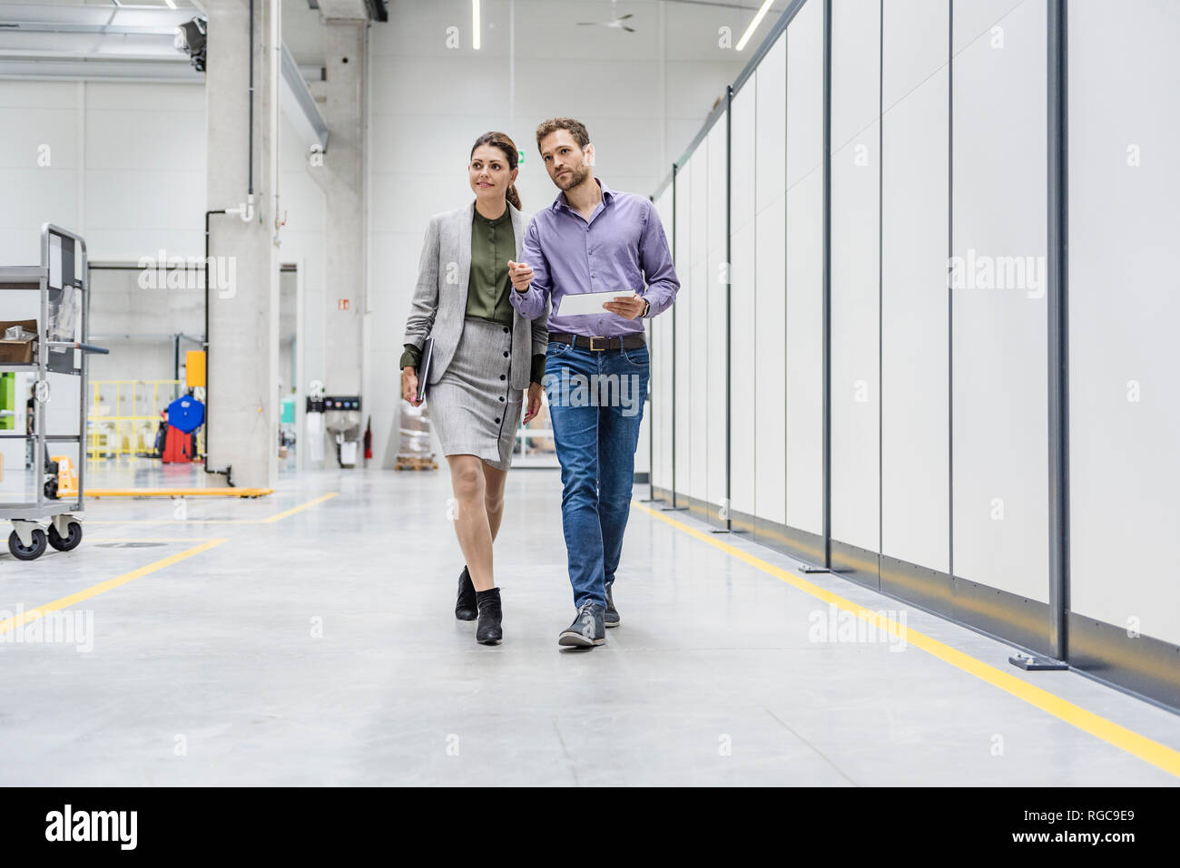 Businessman and woman walking in company, discussing new strategies Stock Photo