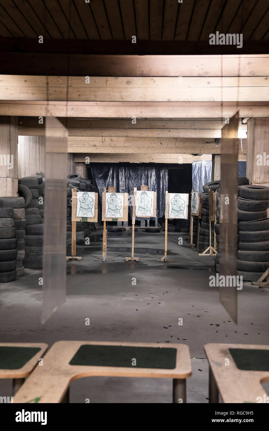 Boards with male likeness as targets in an indoor shooting range Stock Photo
