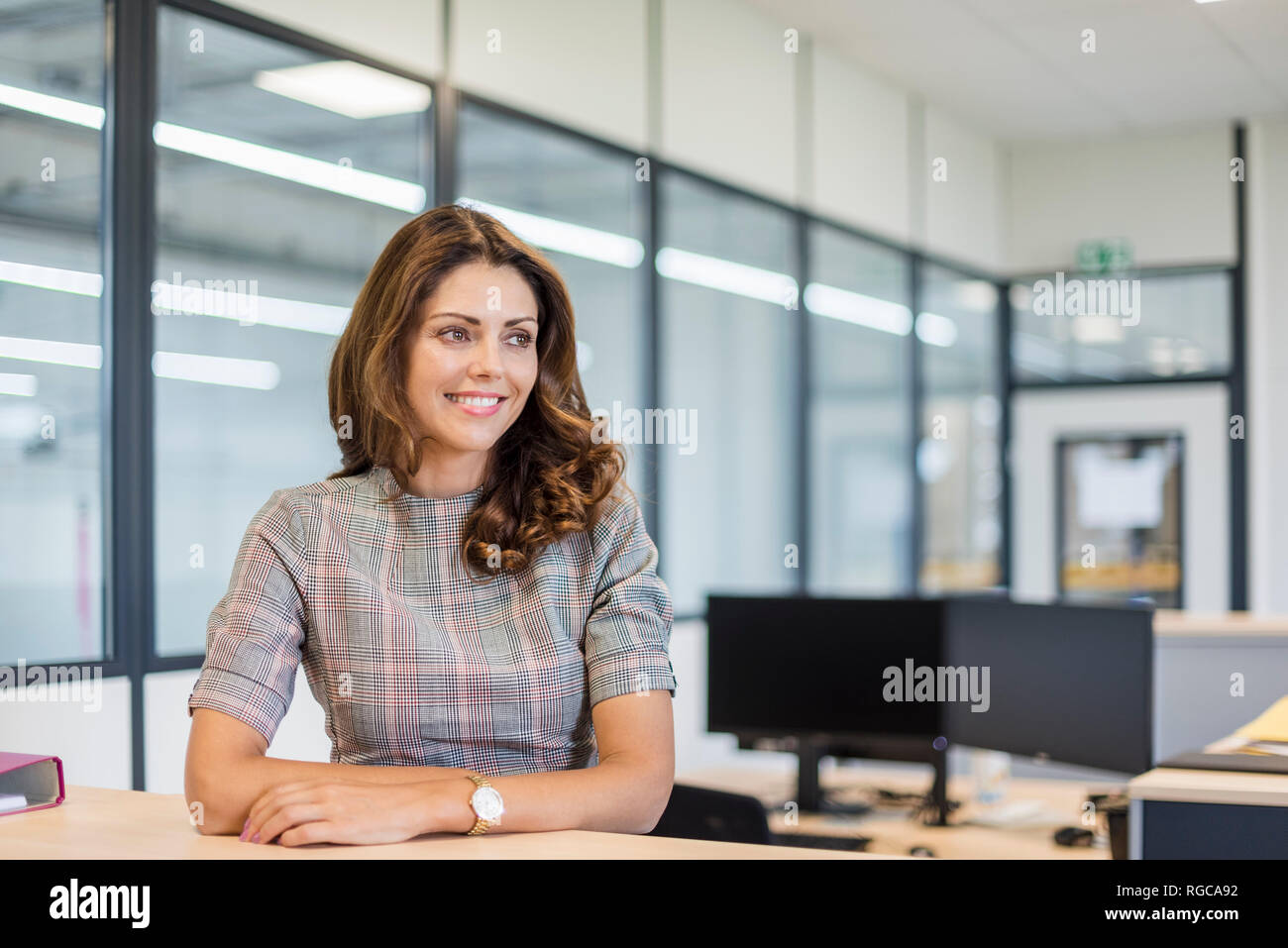 Smiling office worker sitting at desk Stock Photo