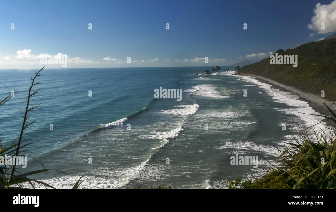 surf rolls in onto a beach on the west coast of new zealand's south island Stock Photo