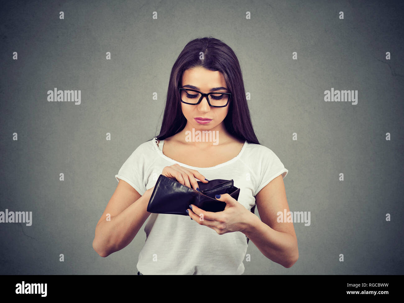 Sad young woman with no money holding an empty wallet Stock Photo - Alamy