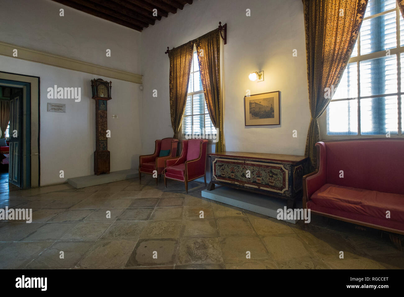 Red sofas line a corridor at the Kornesios Mansion in