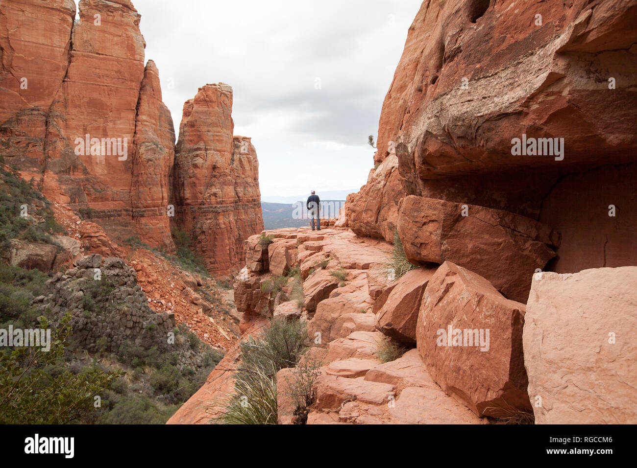 Man hiking to the cliffs edge at cathedral rock trail in Sedona arizona Stock Photo