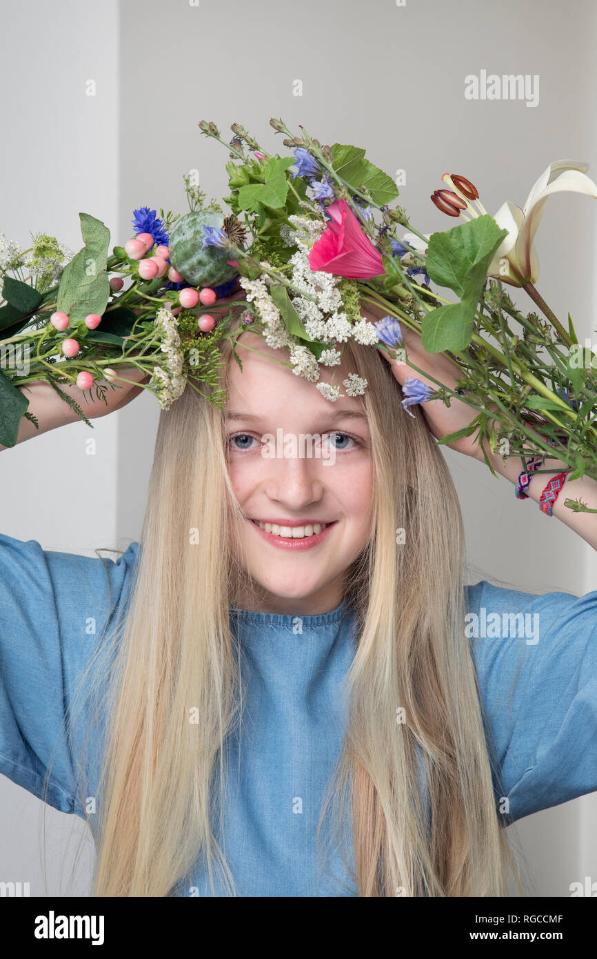 Portrait of smiling blond girl with bunches of flowers Stock Photo