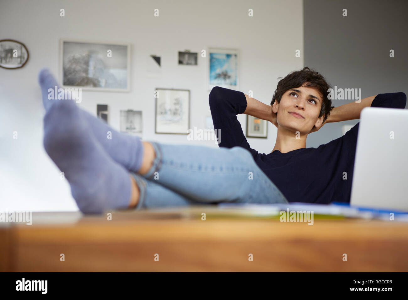 Woman at home sitting at table with laptop Stock Photo