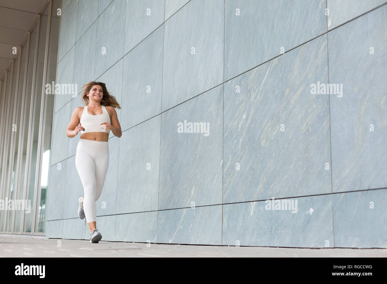 Jogging young woman dressed in white Stock Photo