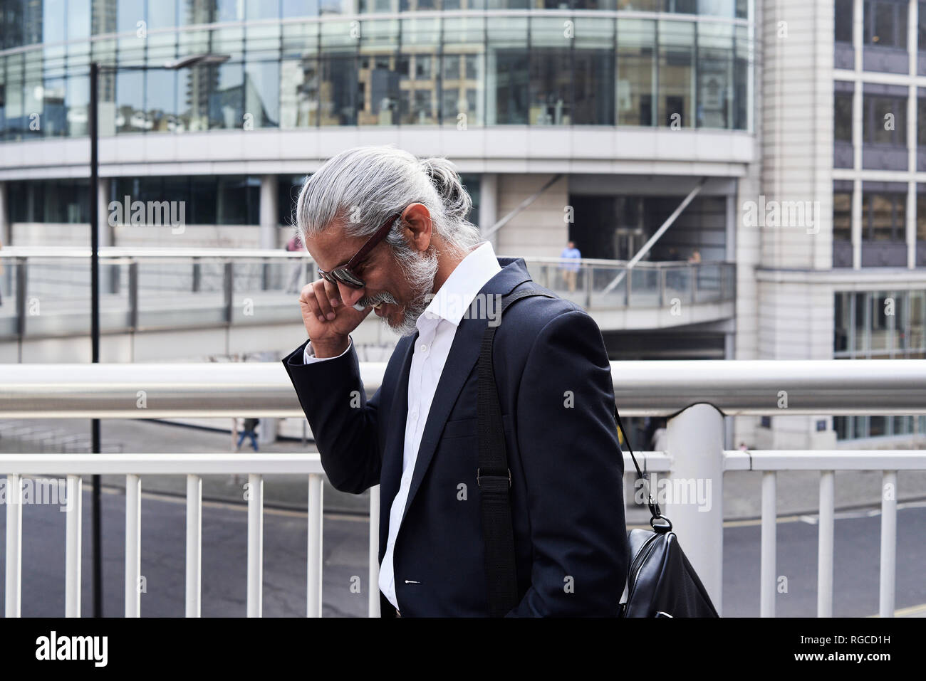Grey-haired senior businessman talking on the phone Stock Photo