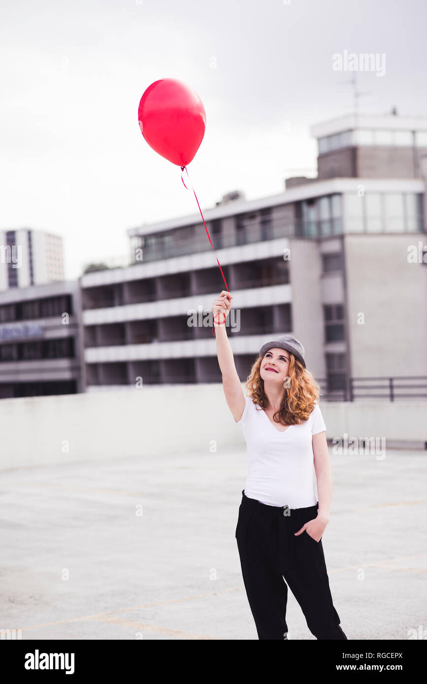Smiling young woman with red balloon Stock Photo