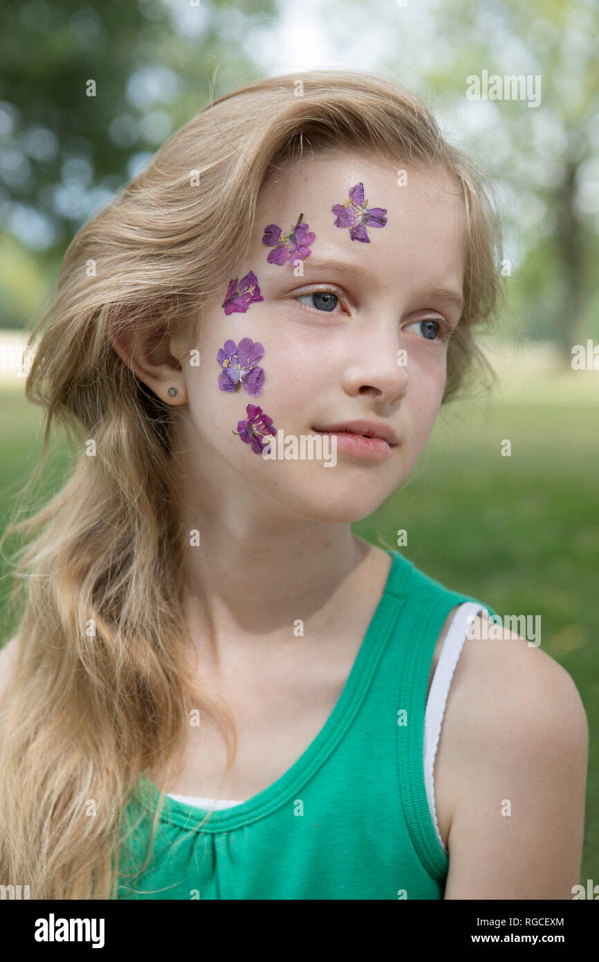 Portrait of blond girl with tattoo of pressed flowers on her face Stock Photo