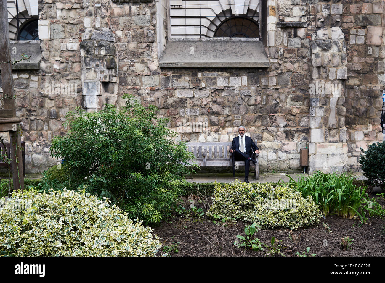 UK, London, senior businessman sitting on bench in a courtyard relaxing Stock Photo