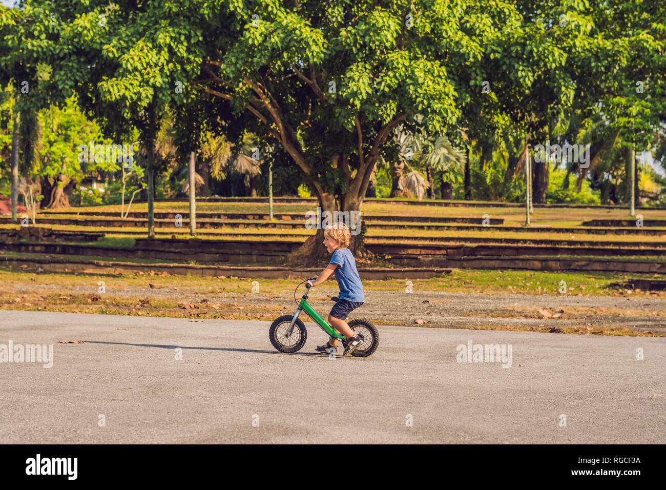 Little boy on a bicycle. Caught in motion, on a driveway. Preschool child's first day on the bike. The joy of movement. Little athlete learns to keep Stock Photo