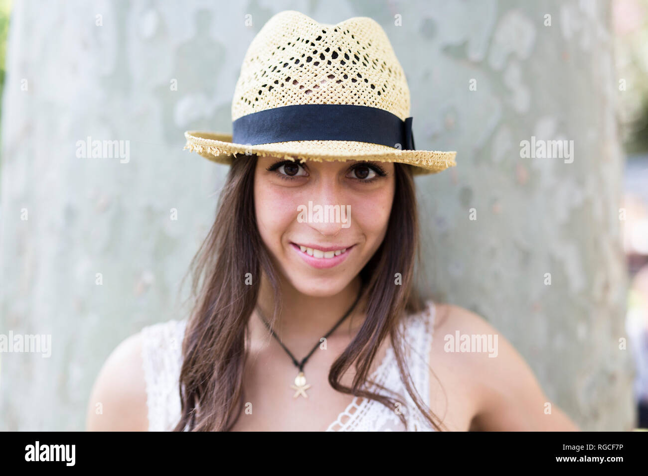 Portrait of smiling young woman wearing straw hat Stock Photo - Alamy