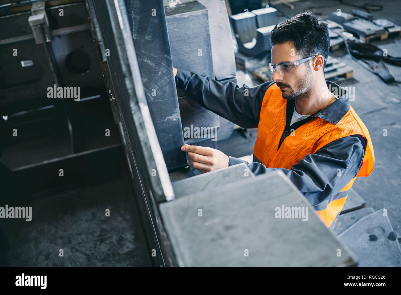 Man wearing protective workwear working in factory Stock Photo