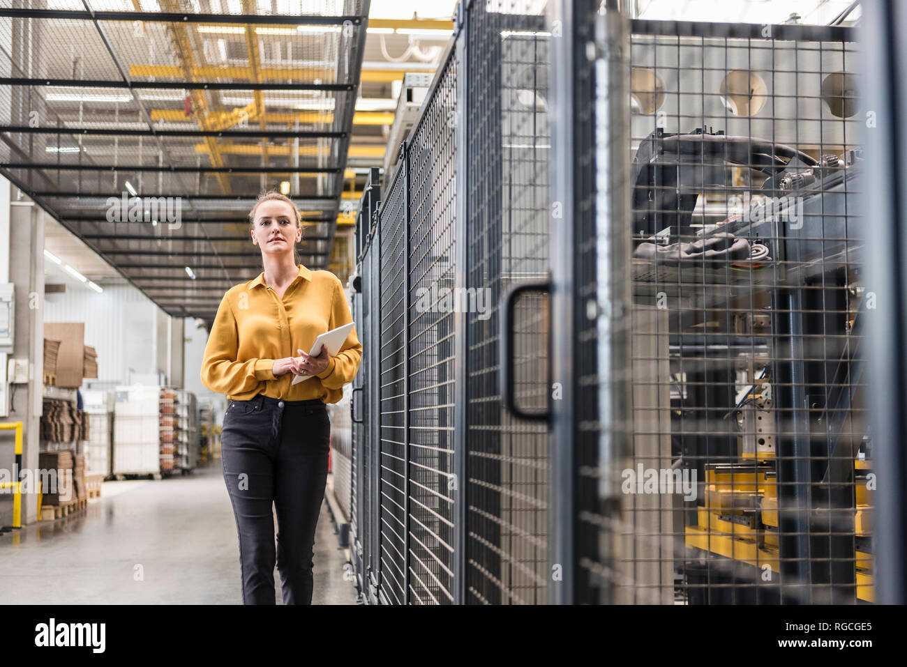 Woman with tablet walking in factory shop floor Stock Photo Alamy
