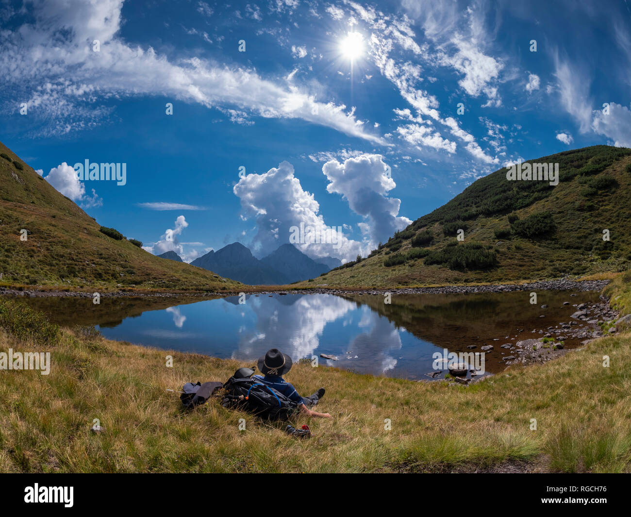 Italy, Lombardy, Bergamasque Alps, hiking lying on lakeside, looking to Mount Camino Stock Photo