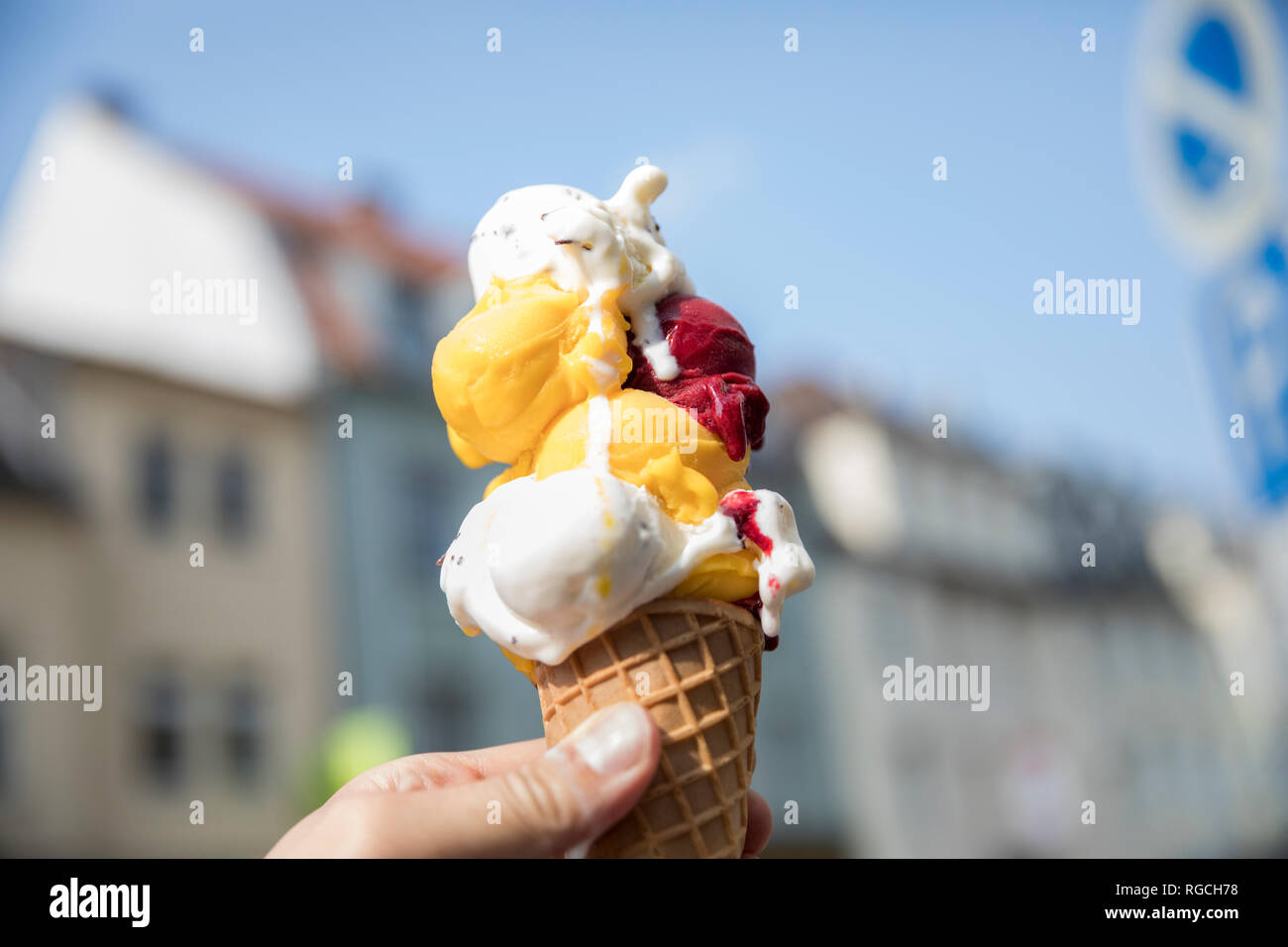 Hand holding ice cream cone with various sorts of ice cream, close-up Stock Photo