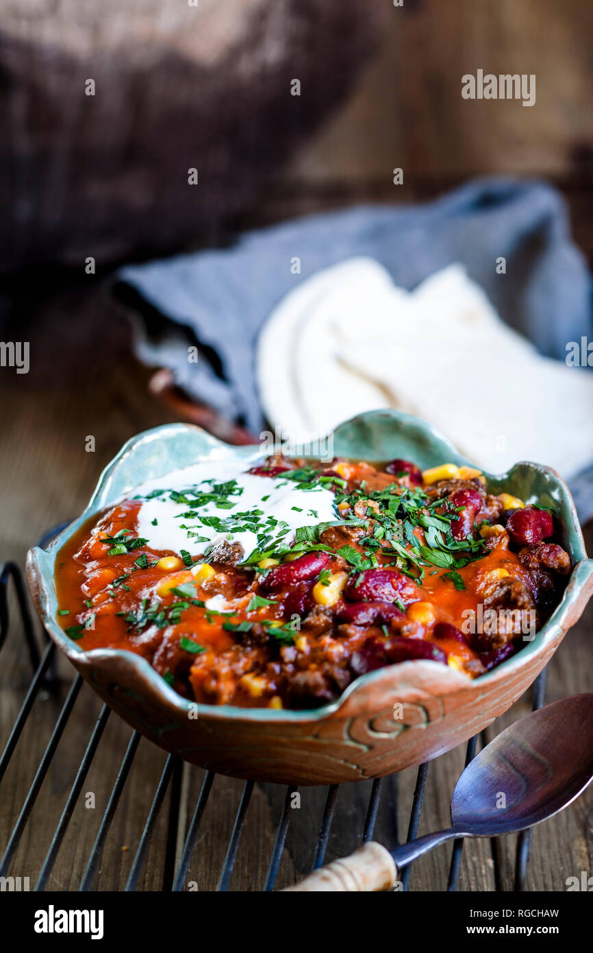 Chili con carne with kidney beans and corn, sour cream, parsley, tortilla bread Stock Photo