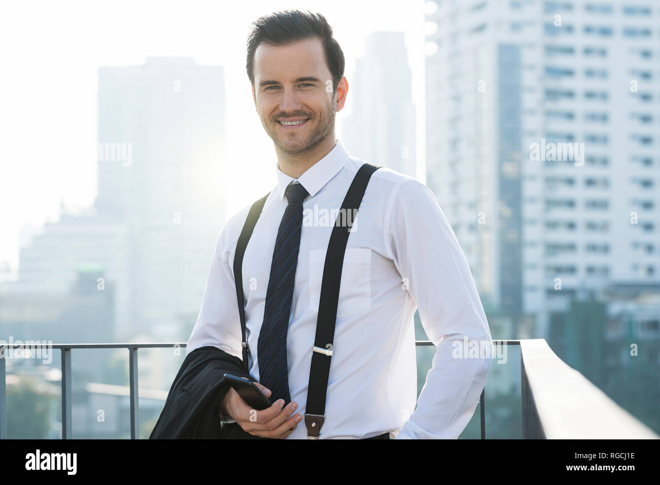 Portrait of business man on city rooftop Stock Photo