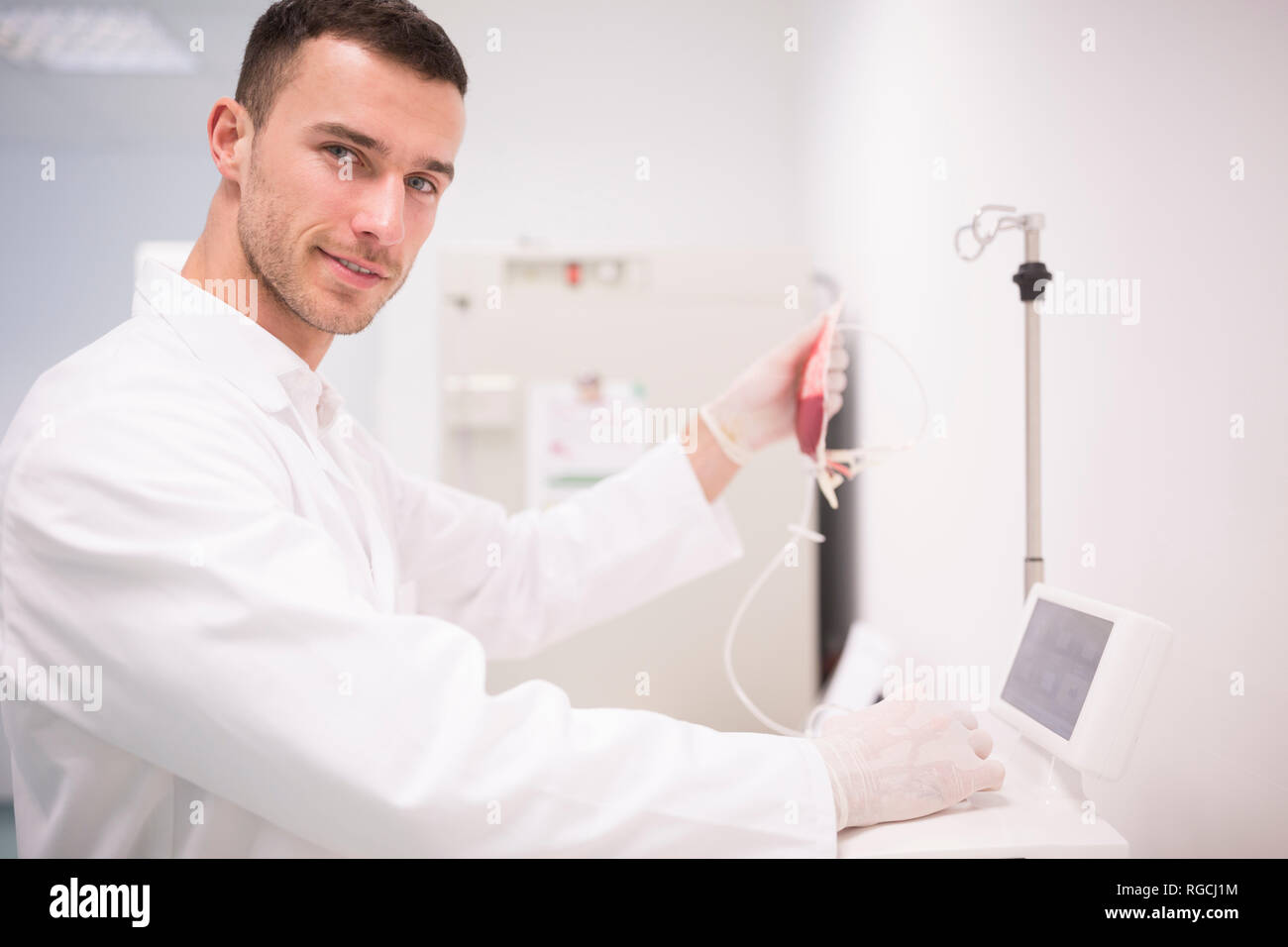 Portrait of smiling lab technician with blood bag Stock Photo