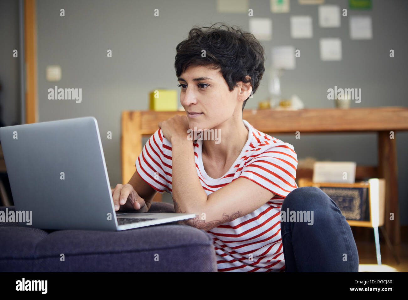 Smiling woman using laptop at home Stock Photo
