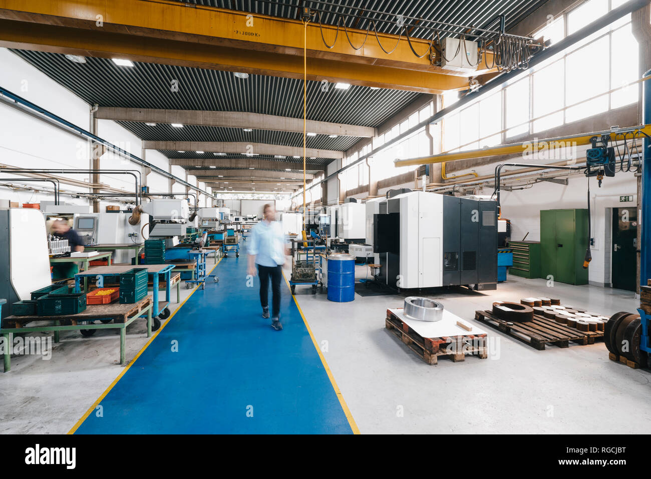 Businessman walking through factory workshop Stock Photo