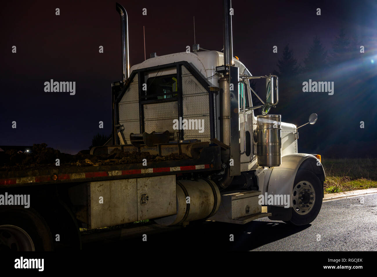 Big rig day cab semi truck with flat bed semi trailer standing on the