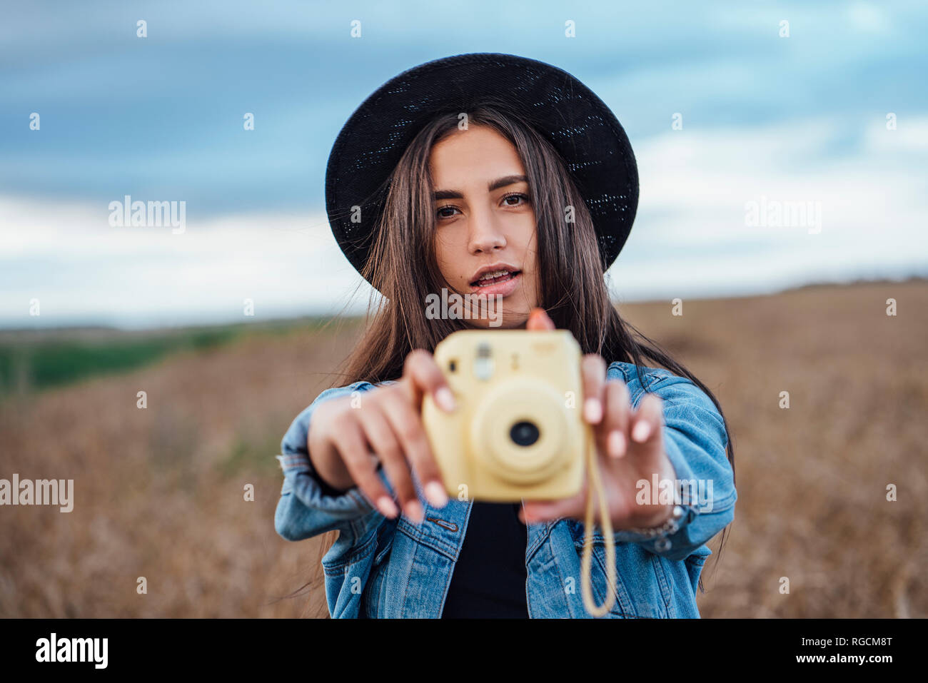 Portrait of young woman taking photo of viewer Stock Photo