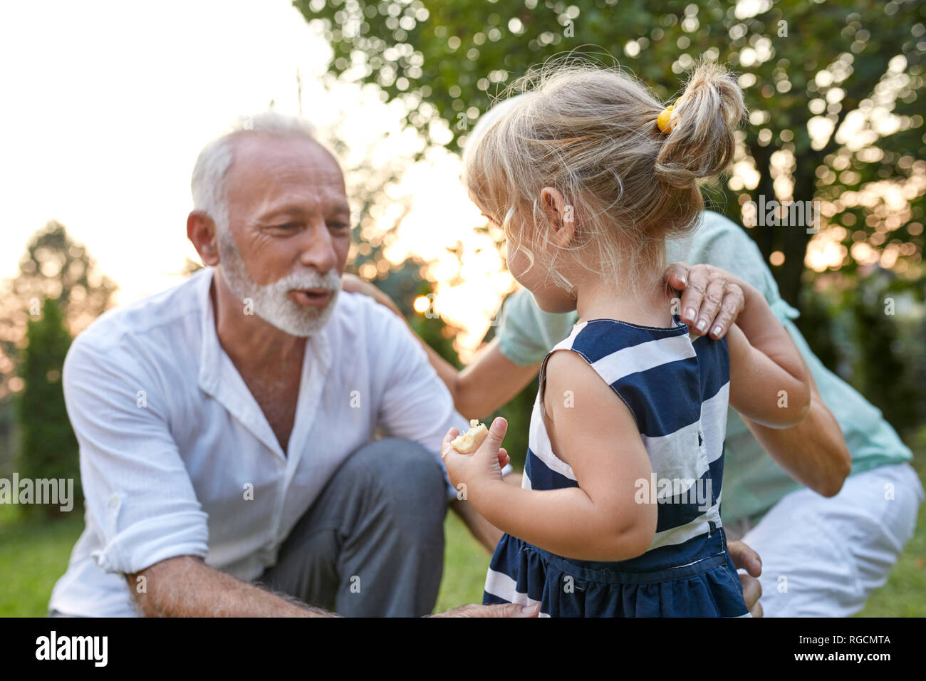 Grandparents with granddaughter in garden Stock Photo
