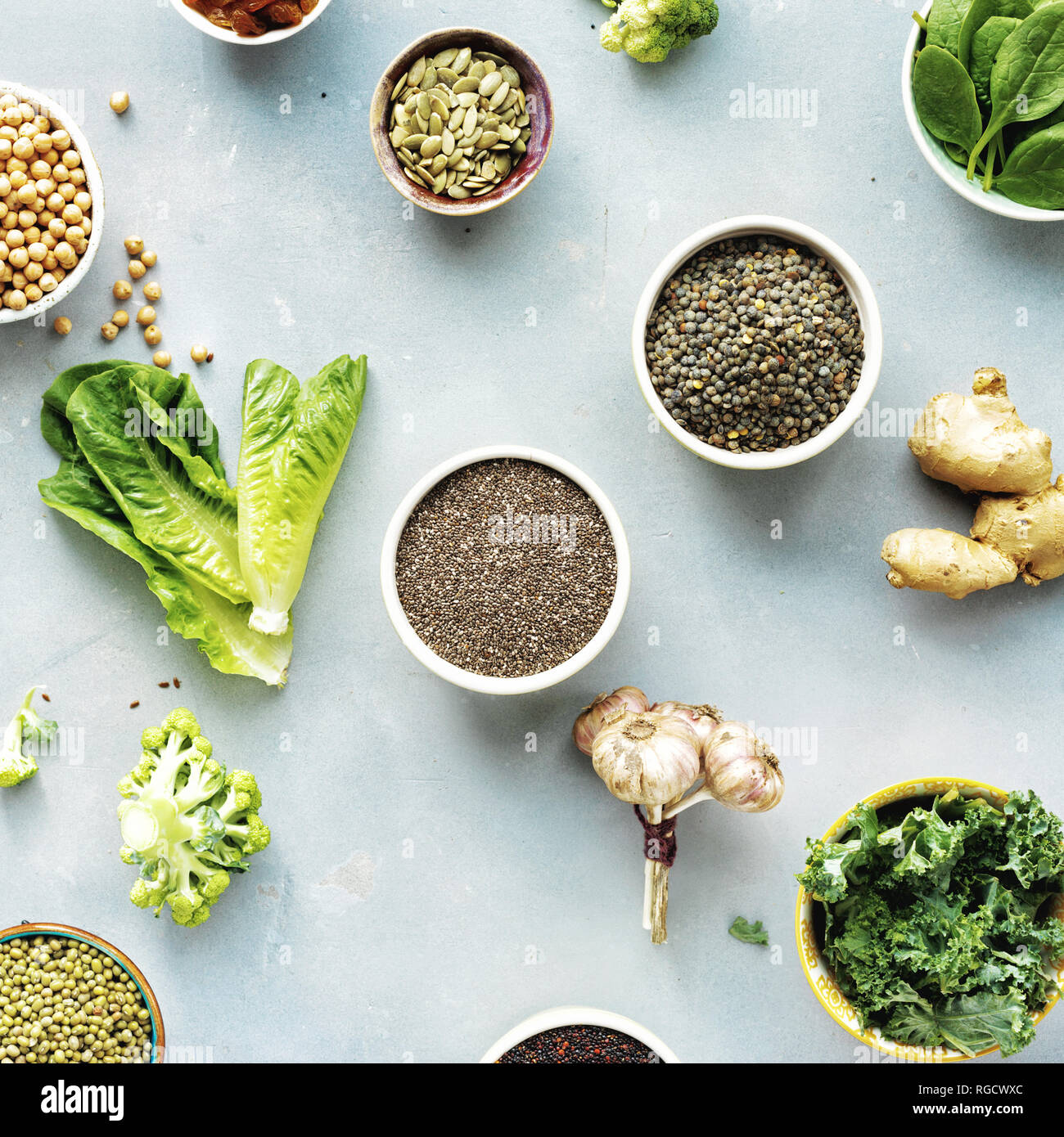 Set raw seeds, cereals, beans, superfoods and green vegetables on blue stone background top view. vegetarian or diet food concept Stock Photo