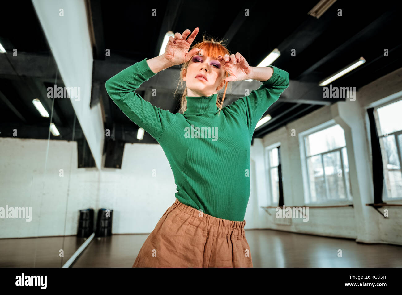 Young red-haired professional choreographer with bright makeup posing Stock Photo