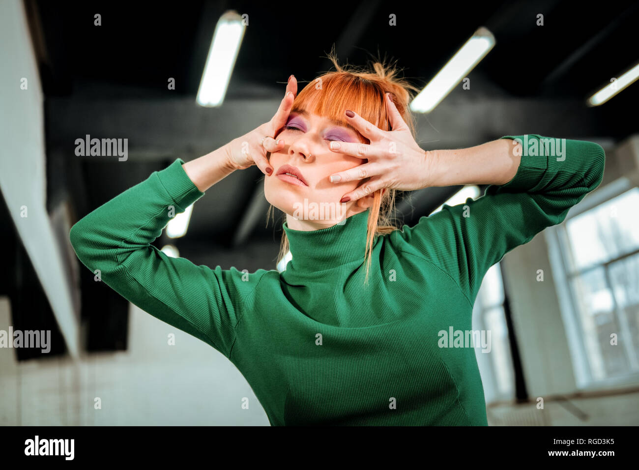 Red-haired professional choreographer with hair bun looking artistic Stock Photo